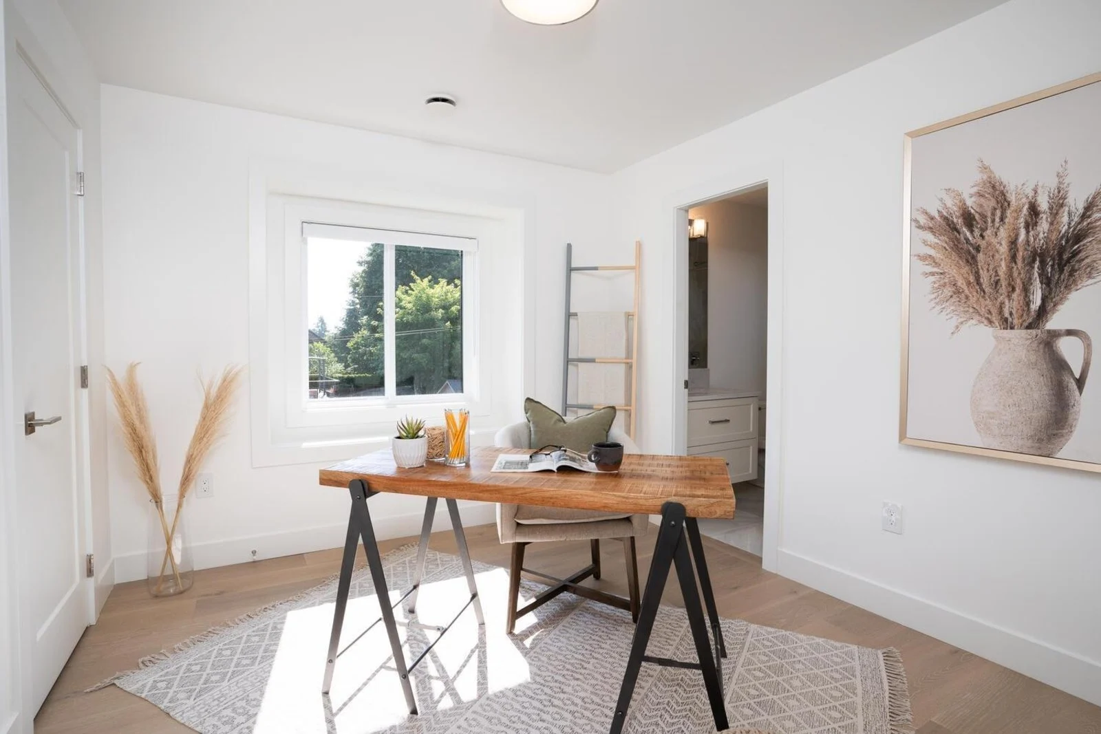 Bright home office with live-edge wood desk, sawhorse legs and pampas grass decor